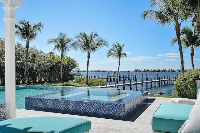 view of swimming pool featuring a pool with connected hot tub, a boat dock, and a water view