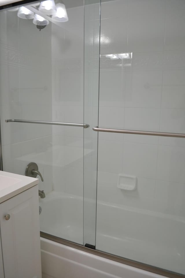 bathroom with bath / shower combo with glass door and vanity