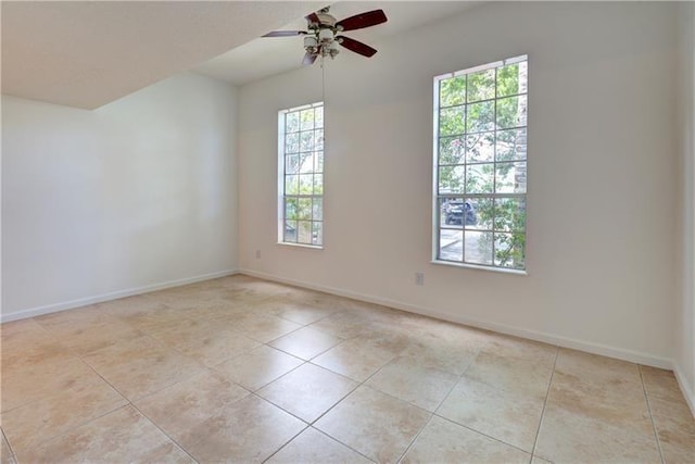 tiled spare room featuring ceiling fan and a wealth of natural light