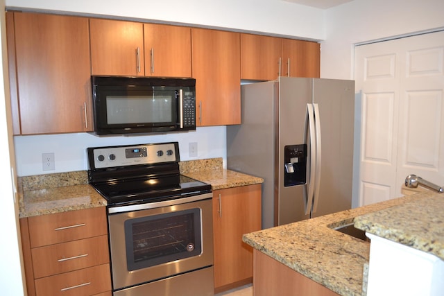 kitchen with light stone countertops and appliances with stainless steel finishes