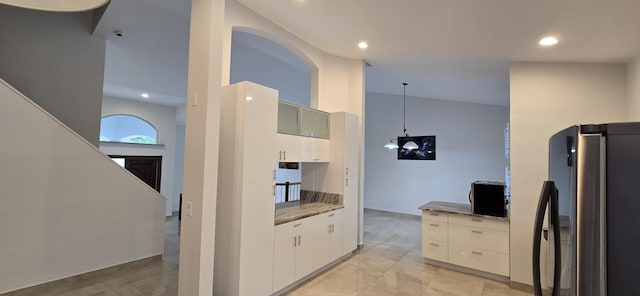 kitchen featuring white cabinetry, pendant lighting, stainless steel fridge, and a chandelier