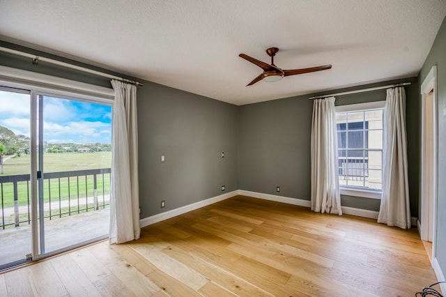 spare room with ceiling fan, light hardwood / wood-style floors, and a textured ceiling