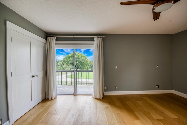 empty room with ceiling fan, a textured ceiling, and light hardwood / wood-style flooring