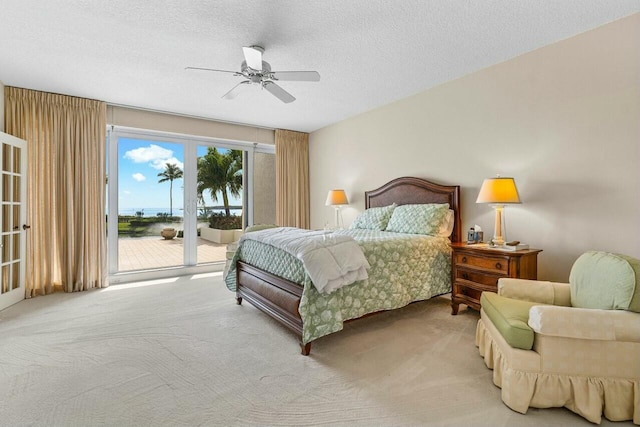 bedroom featuring ceiling fan, carpet, access to exterior, and a textured ceiling