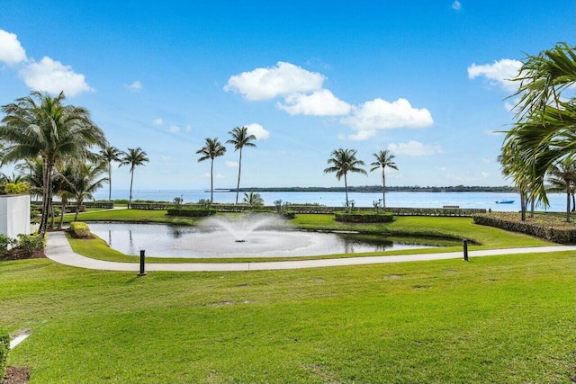 surrounding community with a water view and a lawn