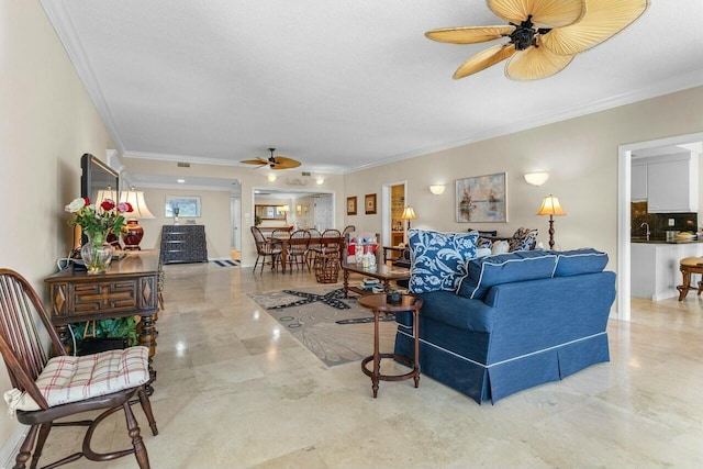 living room with ceiling fan, ornamental molding, and a textured ceiling