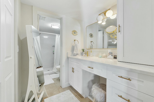 bathroom featuring tile patterned flooring, vanity, curtained shower, and toilet