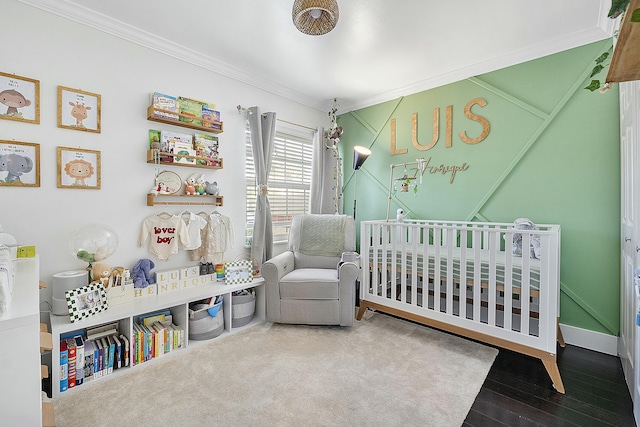 bedroom with a crib, ornamental molding, and wood-type flooring