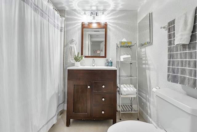 bathroom featuring tile patterned flooring, vanity, and toilet