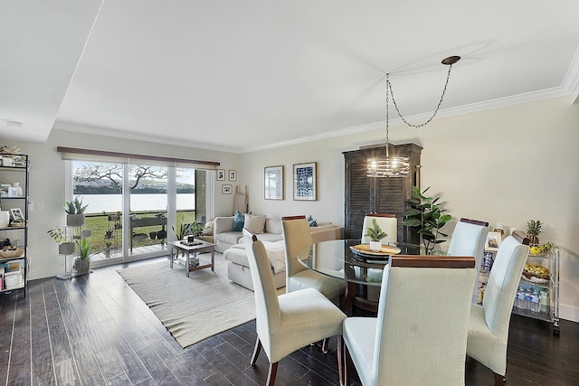 dining room with crown molding, a water view, dark wood-type flooring, and a notable chandelier