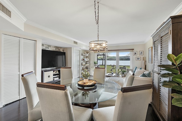 dining space featuring ornamental molding, dark hardwood / wood-style floors, and a notable chandelier