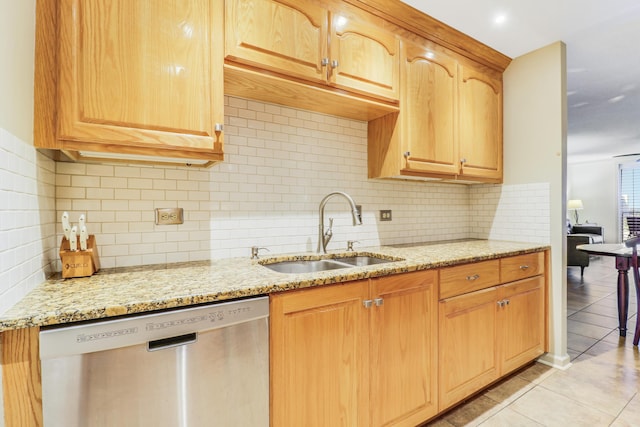 kitchen with sink, dishwasher, tasteful backsplash, light stone countertops, and light tile patterned flooring