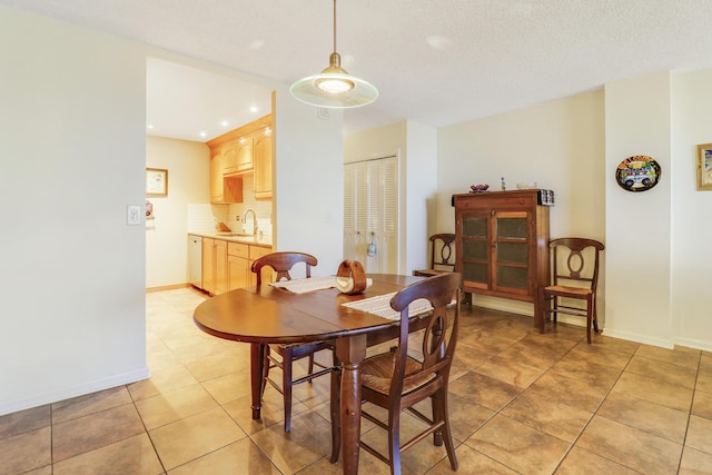 tiled dining space featuring sink and a textured ceiling