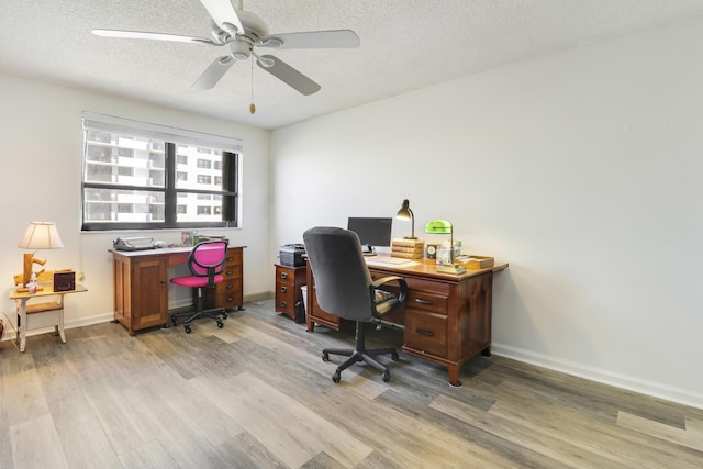 office space with ceiling fan, light hardwood / wood-style flooring, and a textured ceiling