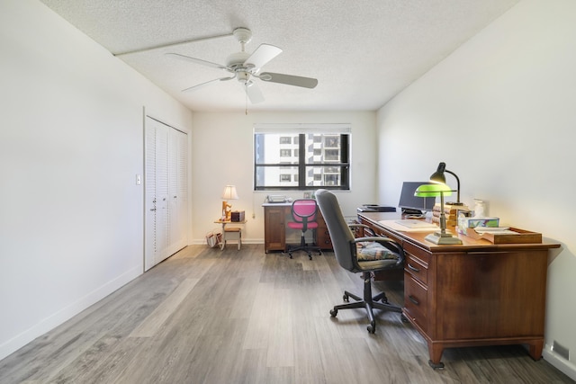 office area featuring hardwood / wood-style flooring, ceiling fan, and a textured ceiling