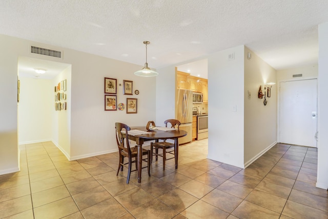 tiled dining area with a textured ceiling