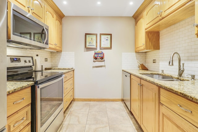 kitchen with sink, light tile patterned floors, appliances with stainless steel finishes, light stone countertops, and light brown cabinetry