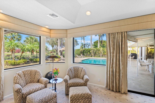 living area featuring light colored carpet and a textured ceiling