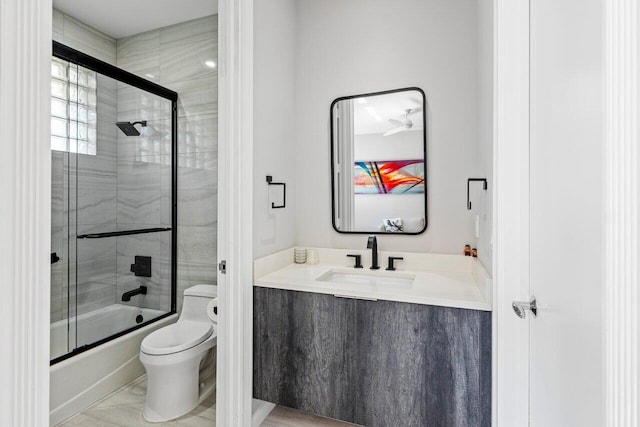 full bathroom with vanity, enclosed tub / shower combo, and toilet