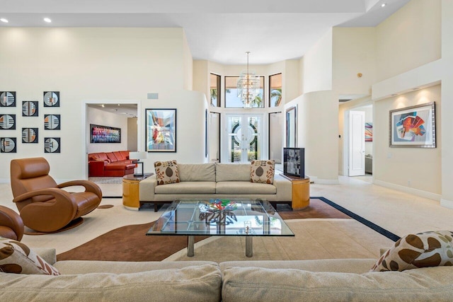 tiled living room with a towering ceiling and a chandelier