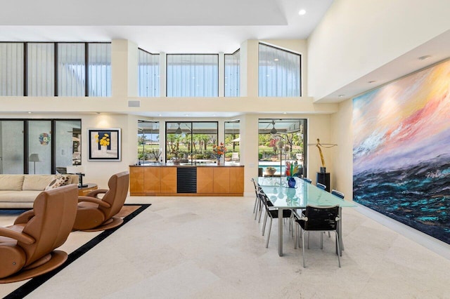 dining space with a towering ceiling and beverage cooler