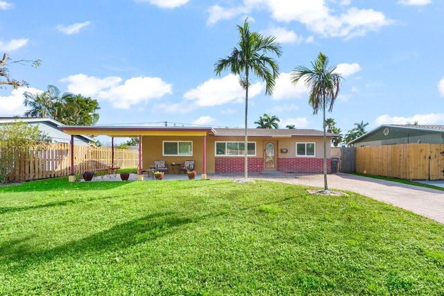 ranch-style home featuring fence, a front lawn, decorative driveway, and brick siding