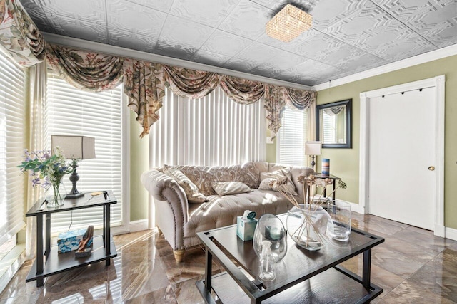 living area featuring marble finish floor, ornamental molding, an ornate ceiling, and baseboards