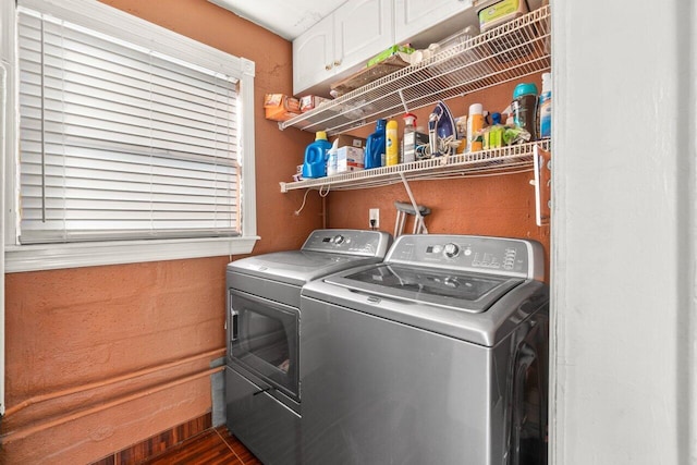 laundry room with washing machine and clothes dryer and cabinet space