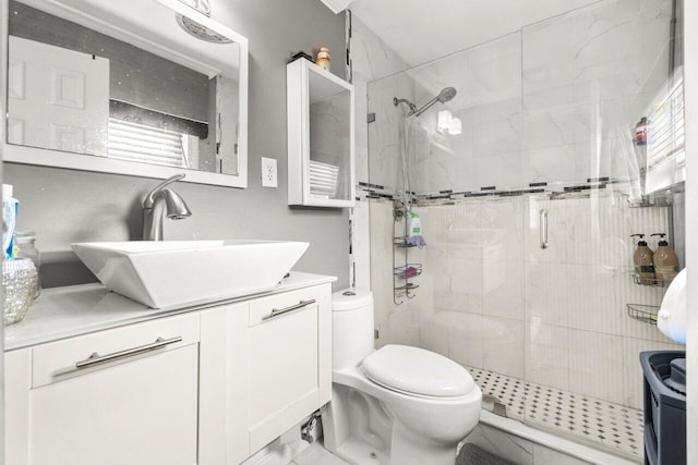 full bath featuring toilet, marble finish floor, a stall shower, and vanity