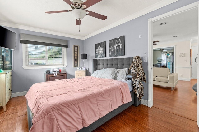 bedroom featuring ornamental molding, dark wood-style flooring, baseboards, and a ceiling fan