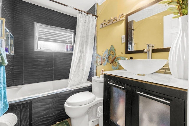 bathroom with tiled shower / bath combo, vanity, and toilet