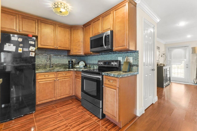 kitchen with appliances with stainless steel finishes, backsplash, dark stone counters, brown cabinetry, and crown molding