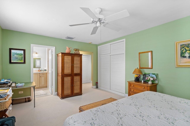 bedroom with ensuite bath, light colored carpet, a closet, and ceiling fan