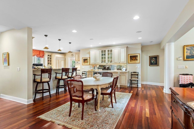 dining area featuring dark hardwood / wood-style flooring and ornate columns