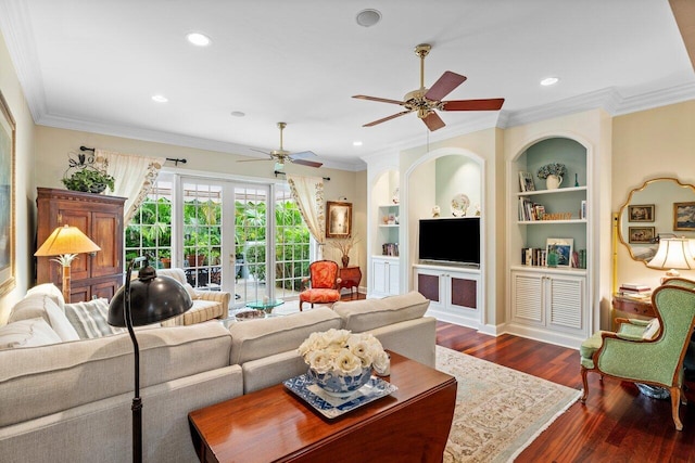 living room featuring ceiling fan, crown molding, built in shelves, dark wood-type flooring, and french doors