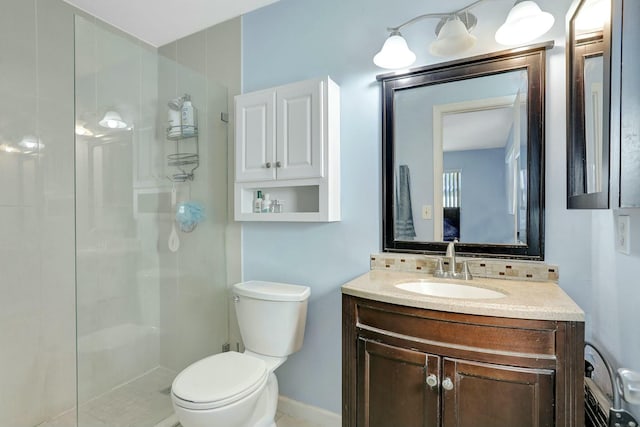 bathroom featuring vanity, a shower with shower door, and toilet