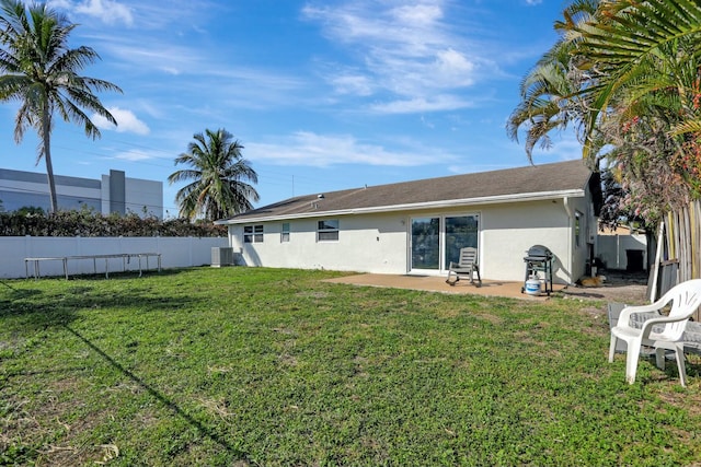 rear view of property with central AC, a patio, and a lawn