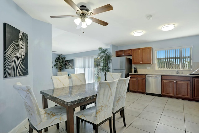 tiled dining area featuring sink, a wealth of natural light, and ceiling fan