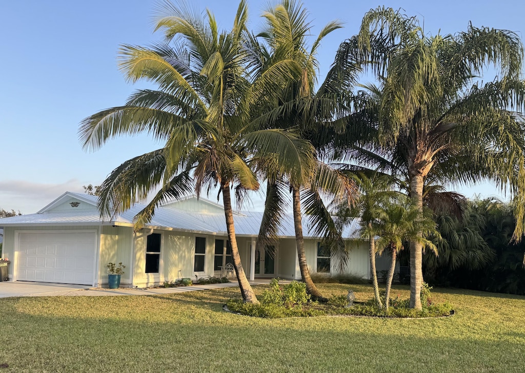 single story home featuring a garage and a front lawn