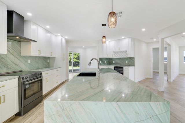 kitchen featuring tasteful backsplash, beverage cooler, electric range, wall chimney range hood, and a sink