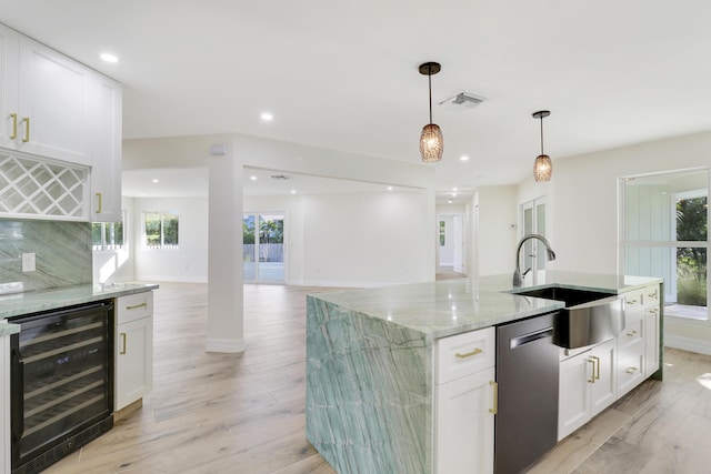 kitchen with a sink, visible vents, light wood-style floors, dishwasher, and wine cooler
