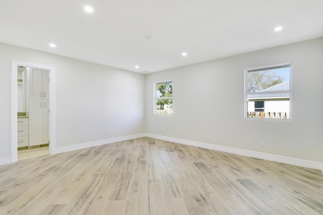 unfurnished room with light wood finished floors, baseboards, and recessed lighting