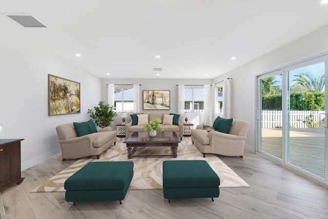 living area featuring light wood finished floors, recessed lighting, visible vents, and baseboards