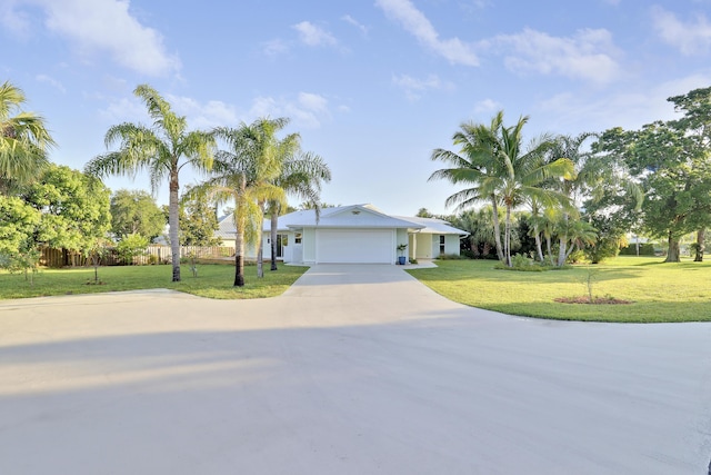 ranch-style home featuring a garage, fence, a front lawn, and driveway