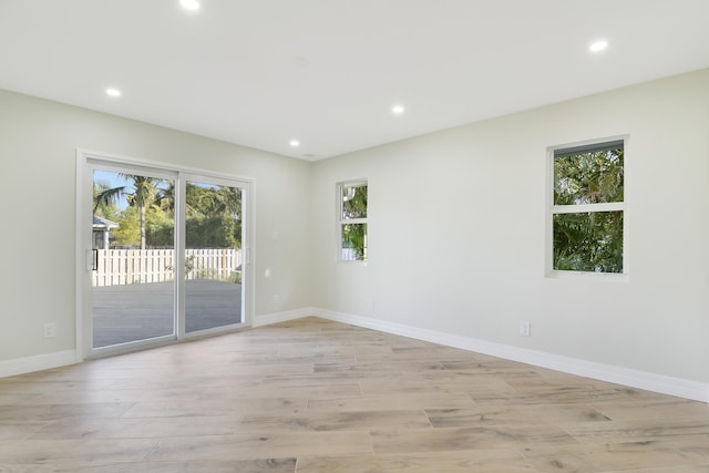 spare room featuring recessed lighting, light wood-type flooring, and baseboards