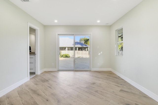 empty room featuring baseboards, recessed lighting, plenty of natural light, and light wood-style floors