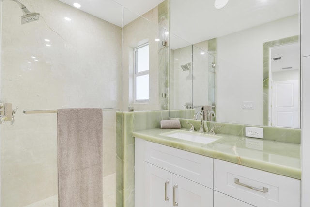 full bathroom featuring a stall shower, visible vents, and vanity