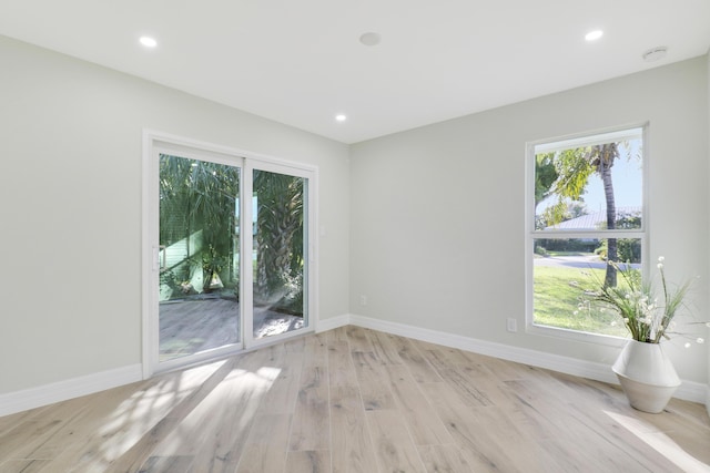 empty room featuring light wood finished floors, recessed lighting, and baseboards