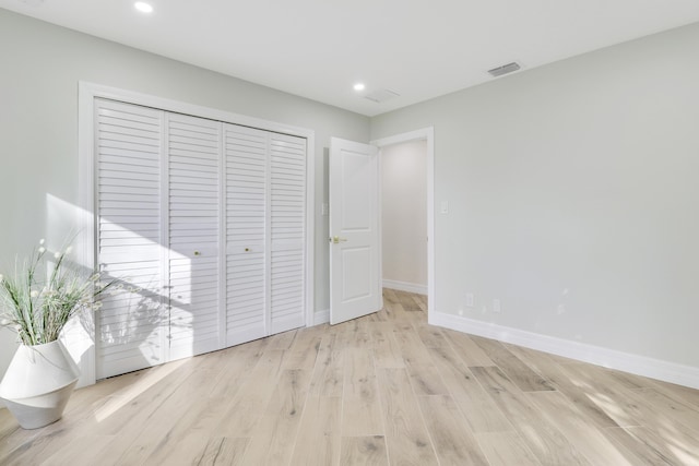 unfurnished bedroom featuring recessed lighting, a closet, visible vents, and light wood-style floors