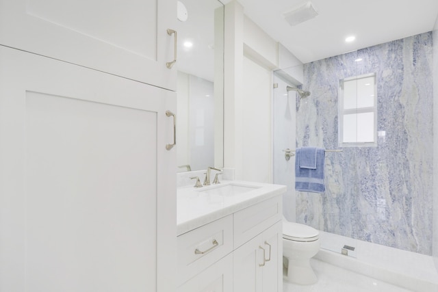 bathroom featuring toilet, a stall shower, and vanity
